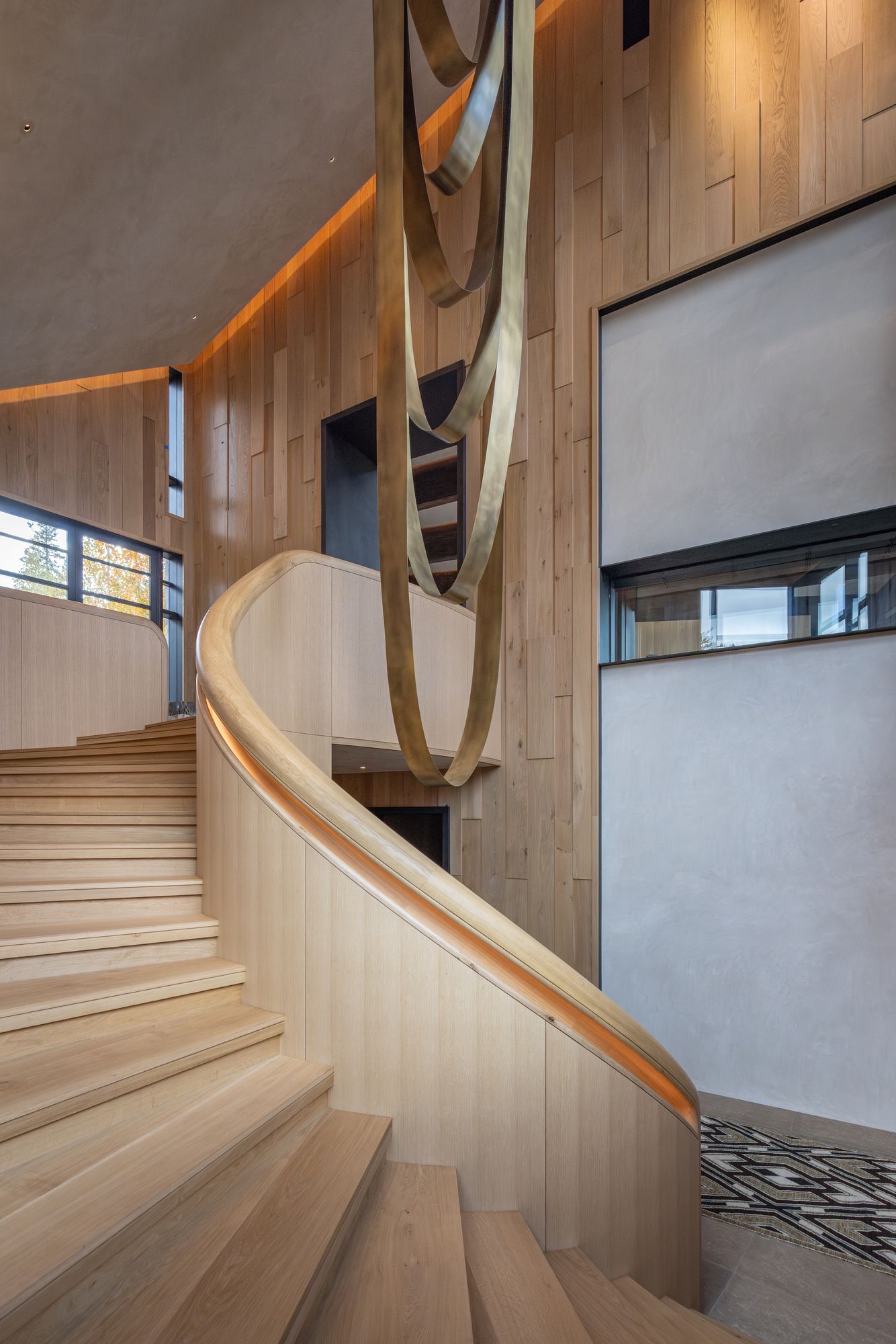 White Oak House: curved white oak staircase with a lit handrail